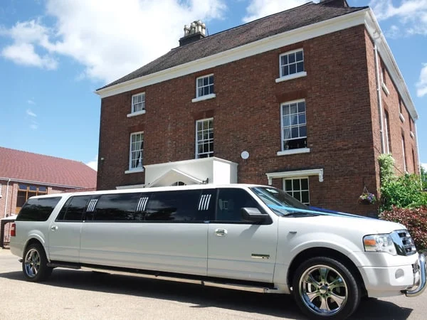 White stretch limousine outside a country house, ready for a prom arrival