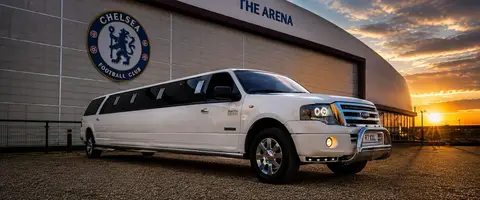 White Ford Expedition GMC Typhoon stretch limousine outside Chelsea FC at sunset